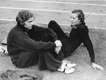 Dora Ratjen (l.) und Elfriede Kaun (r.) sitzen auf dem Rasen eines Sportfelds