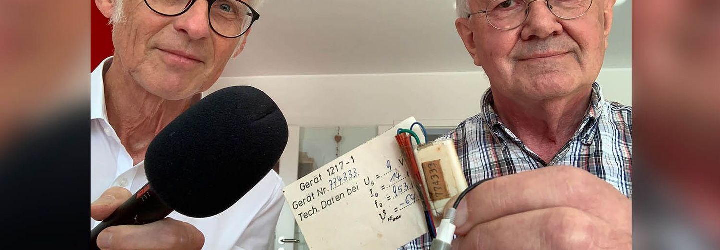 Maximilian Schönherr und Detlev Vreisleben halten eine "Wanze" der Staatssicherheit in die Kamera