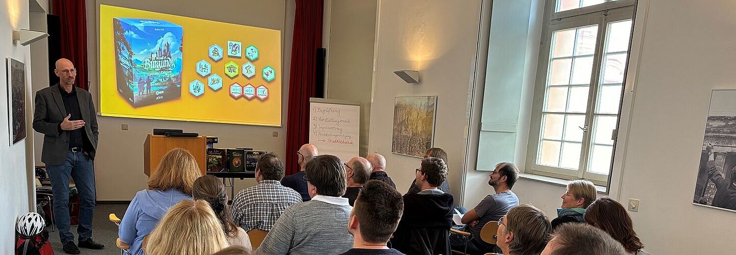 Spieleerfinder Stefan Feld spricht vor dem Publikum