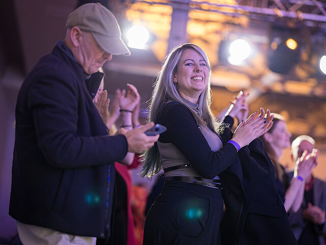 Mehrere Personen sind zu sehen, die in ihre Hände klatschen.