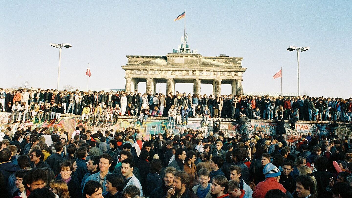 Bild mit Menschen aus West- und Ostberlin auf der Mauer am Brandenburger Tor, 10.11.1989 , Quelle:
            Bundesregierung, B 145 Bild-00100901 / Lehnartz, Klaus