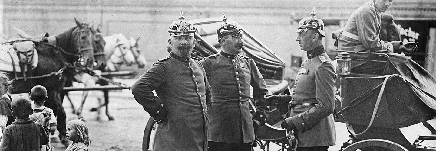 Drei preußische Offiziere vor einer Kutsche (ca. 1900/1914) Drei preußische Offiziere stehen vor einer Kutsche.