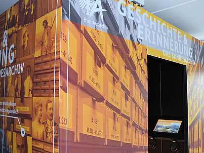 Kubus mit dem Titel der Ausstellung "Geschichte und Erinnerung. Das Bundesarchiv" und Medienstation im Innern