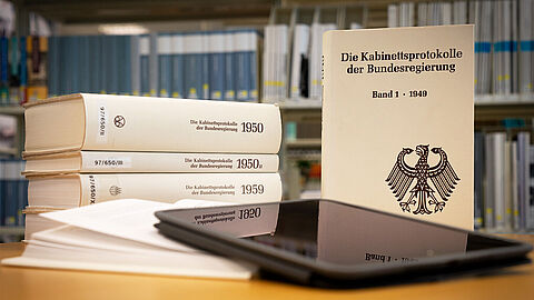 Mehrere Bände der "Kabinettsprotokolle der Bundesregierung" und ein Tablet