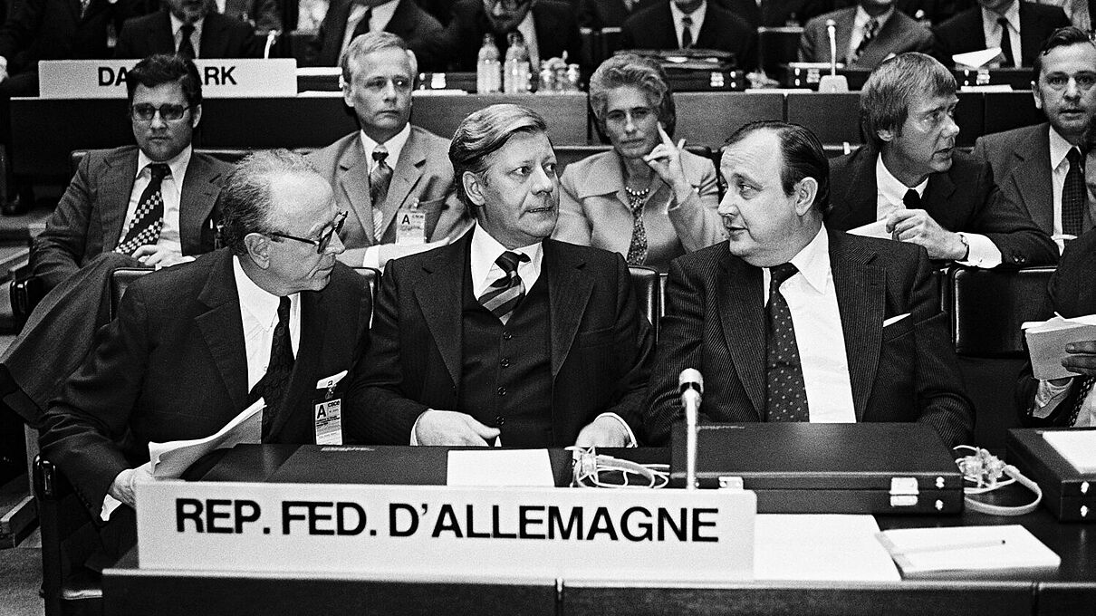 Bundeskanzler Helmut Schmidt (M.) im Gespräch mit Hans-Dietrich Genscher, Bundesminister des Auswärtigen (r.), bei der Konferenz über Sicherheit und Zusammenarbeit in Europa 