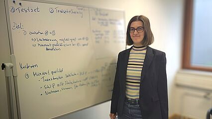 Esther-Maria Lemmerz steht vor einem beschrifteten Whiteboard.