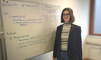 Esther-Maria Lemmerz steht vor einem beschrifteten Whiteboard.