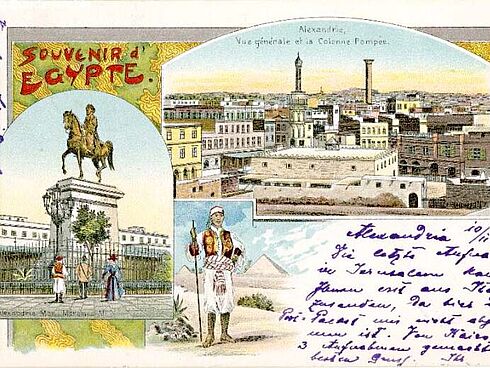 Postkartenbericht an Oskar Messter zur Orientreise des Kaisers. Der Text wurde an den Rand geschrieben, die Mitte der Postkarte zeigen mehrere gemalte Monumente aus dem Orient.