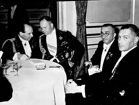Schwarz-Weiß-Fotografie von Ernst Udet bei einem Herrenabend unter anderem mit dem General der Flieger Milch