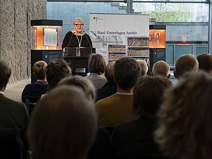 Die SED-Opferbeauftragte Evelyn Zupke steht vor einem sitzenden Publikum an einem Rednerpult.