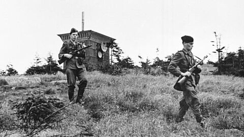 Foto in Schwarz-Weiß, das zwei mit Gewehren bewaffnete Grenzpolizisten im Jahr 1956 auf einer Streife am Brocken zeigt