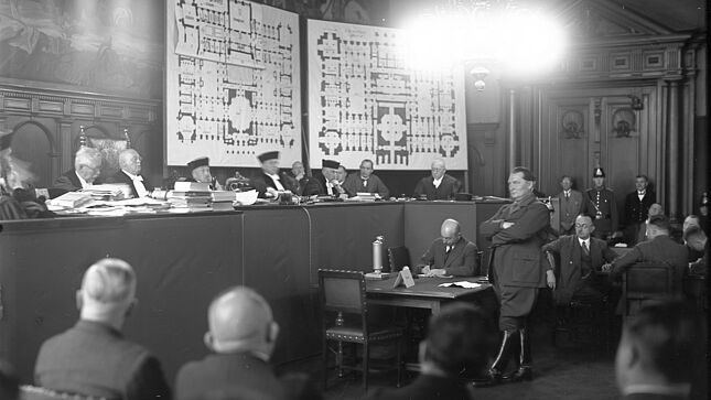 Hermann Göring während seiner Zeugenaussage vor dem Gericht. An der Wand hängen Baupläne des Reichstagsgebäudes
