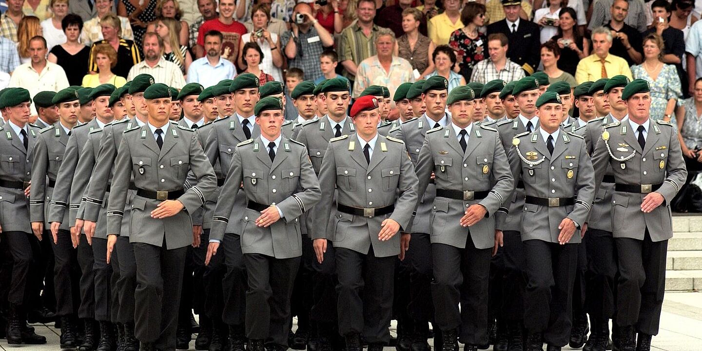 Mehrere Bundeswehrsoldaten marschieren. Im Hintergrund sind Zuschauerinnen und Zuschauer zu sehen., Quelle:
            Bundesregierung,&nbsp;B 145 Bild-00000901 / Bolesch, Sebastian