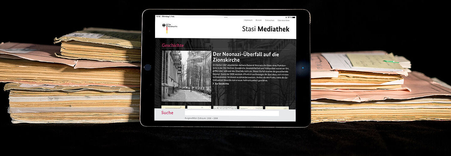 Stasi-Mediathek The picture shows the homepage of the Stasi media library opened on a tablet. The tablet is leaning against some files.