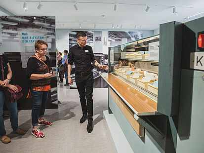 A tour through the exhibition. Visitors can see an original index card paternoster.