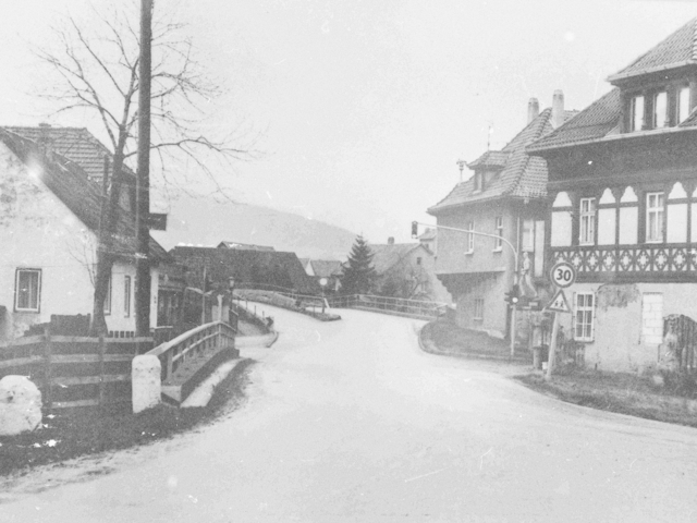 Aufnahme einer Straßenkreuzung mit beginnender Brücke in einem Wohnviertel