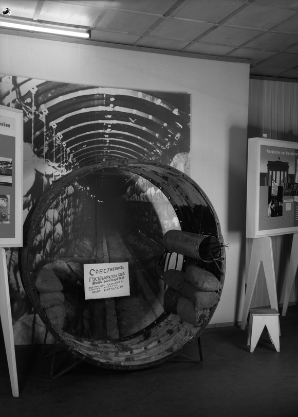 Das Bild zeigt ein Tunnelsegment vor einem großformatigen Bild des Spionagetunnels.