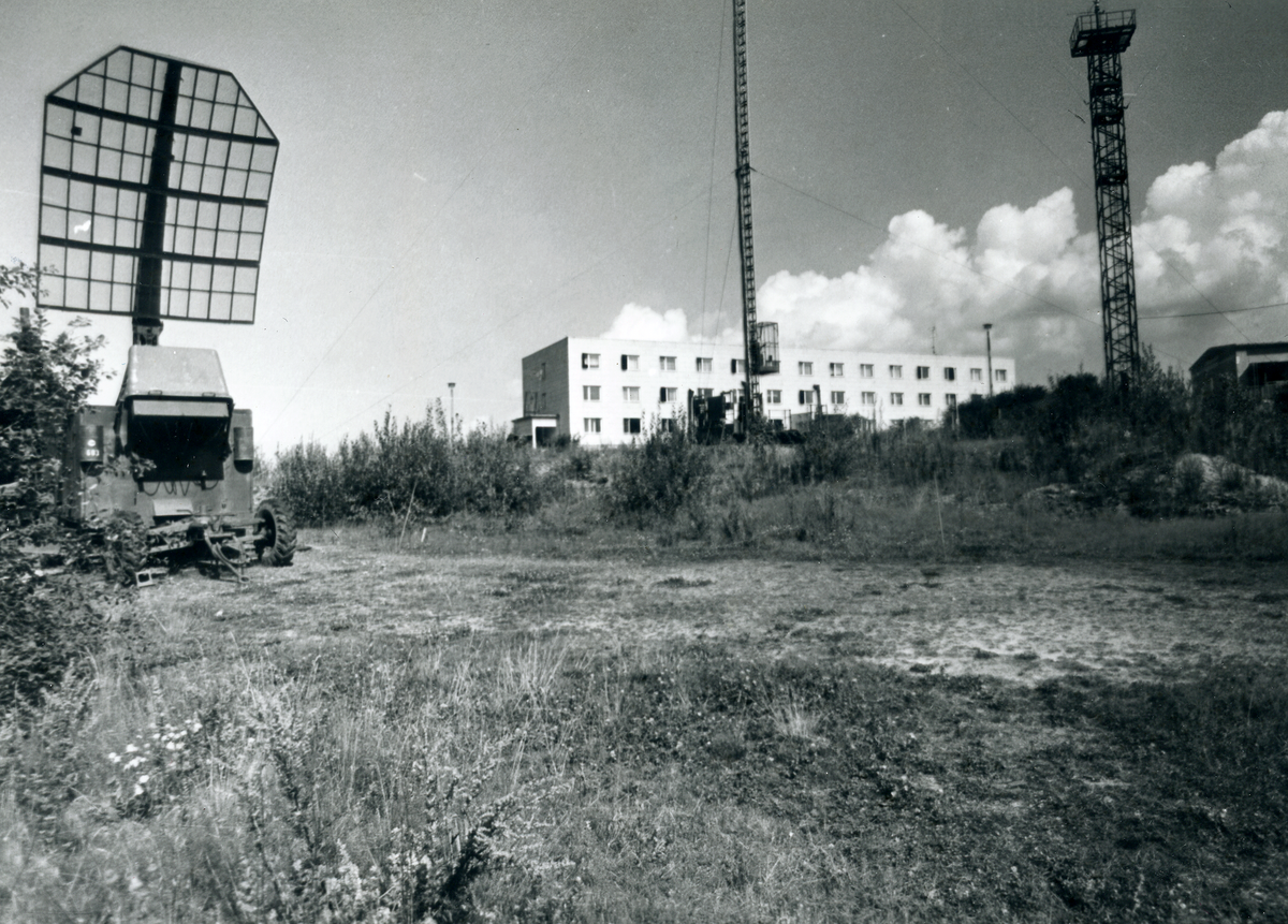 Das Bild zeigt eine Bergkuppe, auf der sich mehrere Gebäude und funktechnische Anlagen befinden.