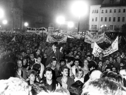 [Zu sehen ist eine Menschenmenge auf einem schwarzweißen Lichtbild. Es sind auch einige Transparente und Plakate mit politischen Forderungen.] 