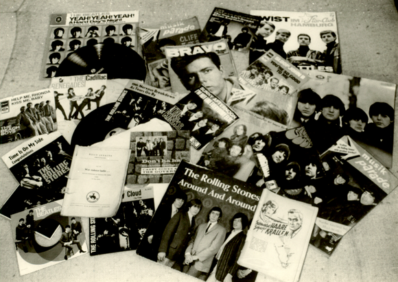 Schwarzweißaufnahme von Zeitschriften und mehreren Plattencovern, darunter LPs von den Beatles und den Rolling Stones