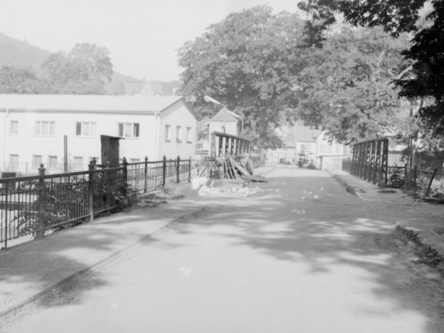 Aufnahme auf einer Brücke mit Blick auf mehrere Häuser und Sperrgut am Rand