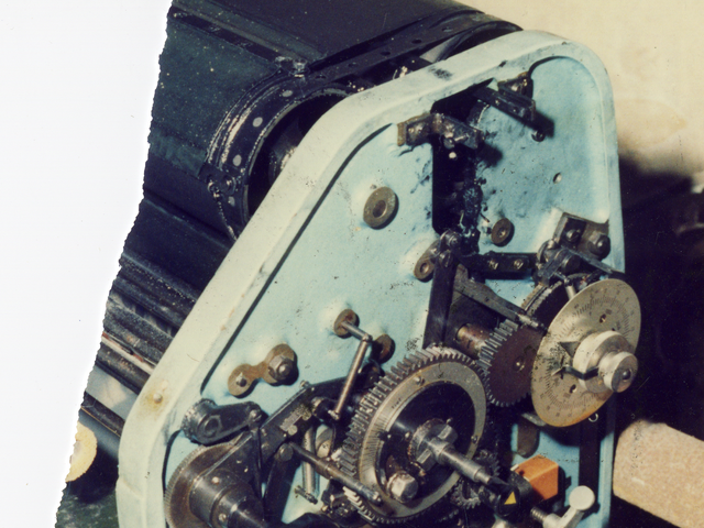 Zerrissenes Foto einer Druckmaschine im Keller der Umweltbibliothek vor einem Bücherregal.