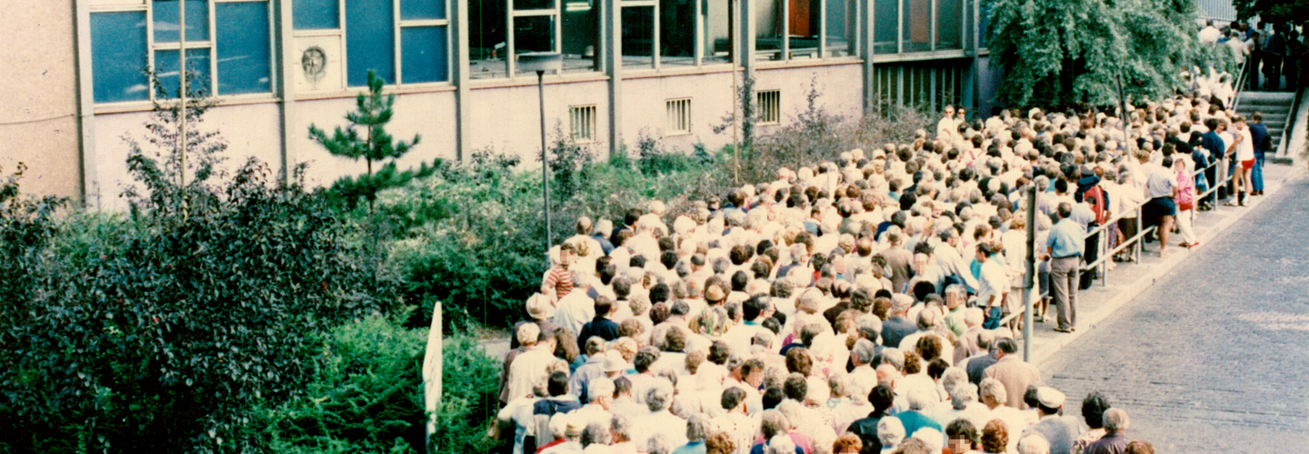 Blick auf eine Menschenschlange vor dem Tränenpalast am Bahnhof Friedrichstraße.
